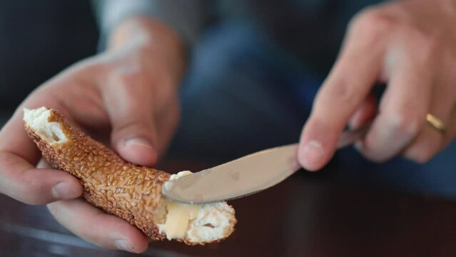 Male hands spread butter on a piece of bread. Breakfast time