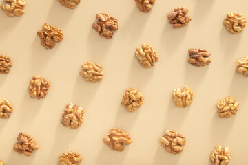 Fototapeta na wymiar Pattern with peeled halves of walnuts top view. Food abstract background with nuts