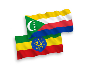 National vector fabric wave flags of Union of the Comoros and Ethiopia isolated on white background. 1 to 2 proportion.