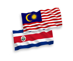 National vector fabric wave flags of Republic of Costa Rica and Malaysia isolated on white background. 1 to 2 proportion.