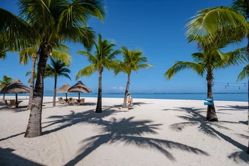 Foto auf Acrylglas Le Morne, Mauritius Le Morne beach Mauritius Tropical beach with palm trees and white sand blue ocean and beach beds with umbrellas, sun chairs, and parasols under a palm tree at a tropical beach. Mauritius Le Morne