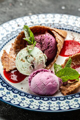 Tasty appetizing ice cream in waffle cones with mint on dark background. Top View