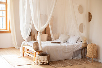 hygge decor at home. interior white bedroom in boho  style with coffe table,straw lamp and...