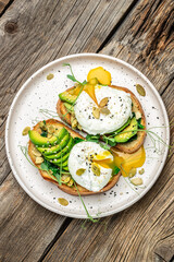 Fototapeta na wymiar Sandwich with spinach, avocado, egg and pumpkin seeds on the wooden table, Healthy food, keto diet, diet lunch concept. vertical image. top view. place for text
