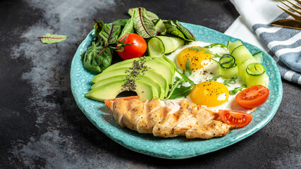 Ketogenic diet breakfast. Chicken grilled fillet with salad fresh tomatoes, cucumbers, eggs and avocado. Low carb high fat breakfast