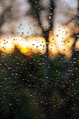 Regentropfen an Fenster bei Sonnenuntergang.