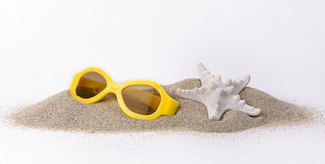 lunettes de soleil et étoiles de mer sur le tas de sable