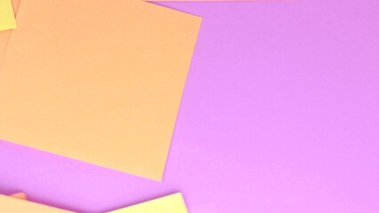 4 to the video, square sheets of yellow note paper fly apart from the wind on a pink paper background, top view
