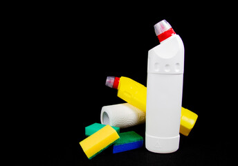 Bottles with cleaning agent, colorful sponges and gloves