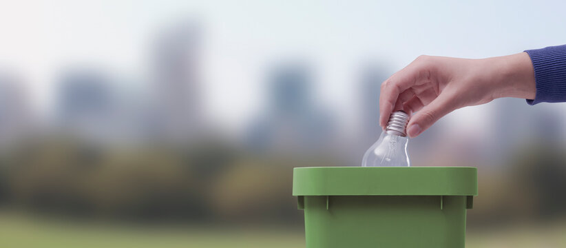 Woman putting a lightbulb in the trash bin