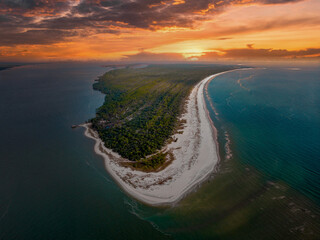 Fototapeta Aerial view of a beautiful island and the sea under the cloudy sunset sky obraz