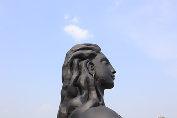 The right side view of the black colored Adi Yogi Shiva statue.