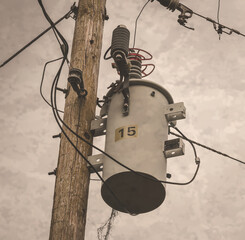 Low angle shot of a power transformer on a wooden pole