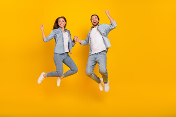 Fototapeta na wymiar Full length body size view of beautiful handsome cheery funny people jumping isolated over bright yellow color background
