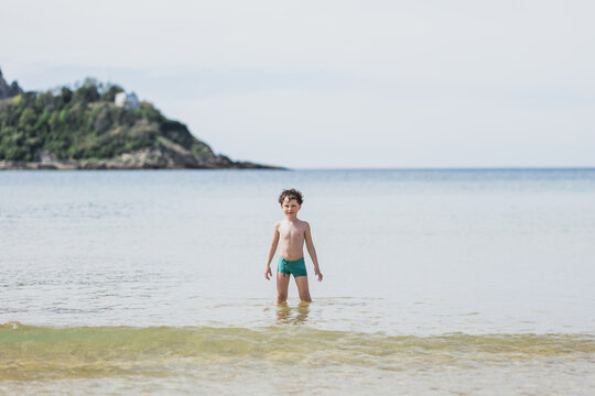 Happy boy standing on sea