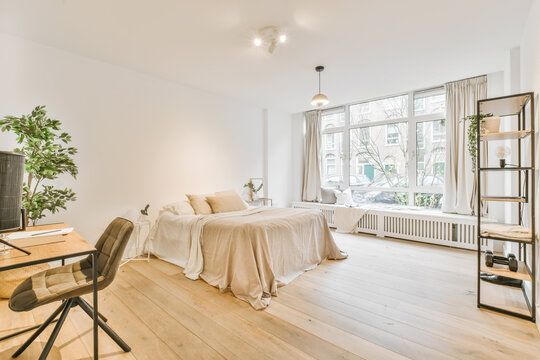 Stylish light bedroom with cozy bed and wooden parquet floor