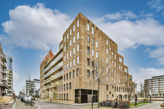 Contemporary building facades against urban pavements under cloudy sky