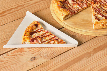 close-up of a slice of pizza in a cardboard box for serving a dish or for delivery, packaging for take away