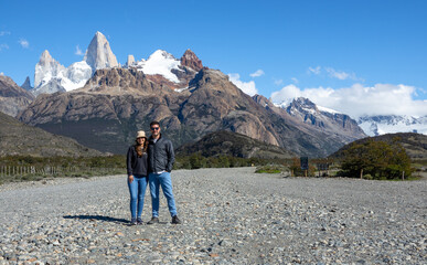 Traveler couple posing in the middle of an empty desert road in Patagonia, near the Desert Lake, Argentina
