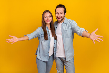 Photo of good mood excited sister brother dressed denim shirts ready hug you isolated yellow color background