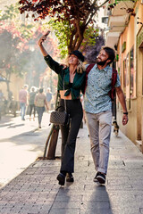 Obraz premium Couple walking on street taking a selfie