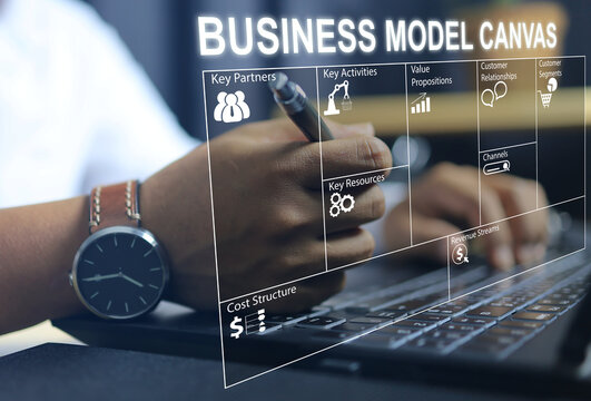 Businessman Planning Business A Plan With Business Model Canvas Through A Laptop On The Desktop For Project Presentation And Budgeting From High Net Worth Investors Value Proposition Cost And Revenue.