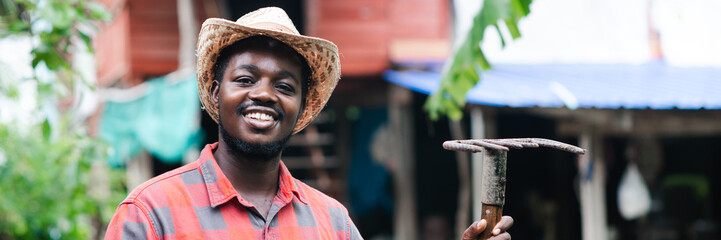 Happiness african male farmer stands with his farmhouse in the background.Agriculture or cultivation concept