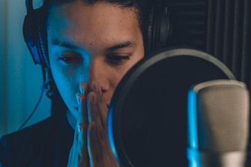 professional male singer in studio recording, attentively listening to the recorded audio.
