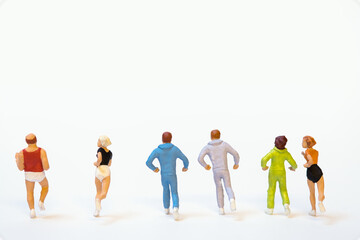 Group of miniature joggers in a row while running on white background