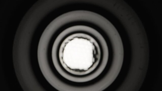 Black pipe inside, light and grid at the end. Dolly slider extreme close-up. Laowa Probe