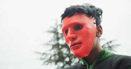 Young South Asian boy in a scary red mask in India