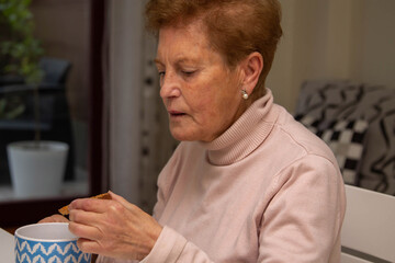 senior woman having cup of coffee and toast at breakfast