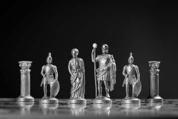 Grayscale host of roman style chess pieces on a chessboard