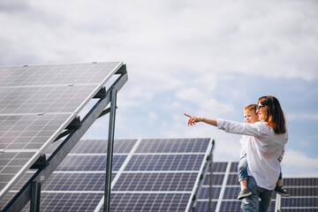 Mother with her little son by solar panels