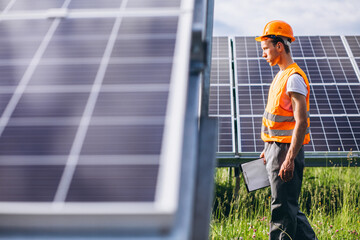 Repair man walking in the field with  solar panels