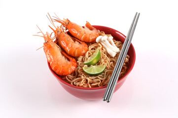 Instant noodles spicy tom Yum kung. Tom Yum kung in a red bowl on a white background top view with chopsticks beside a bowl