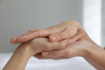 Woman receiving hand massage in wellness center, closeup