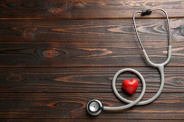 Stethoscope and red heart on wooden table, flat lay with space for text. Cardiology concept - obrazy, fototapety, plakaty