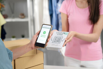 Young woman hand holding smartphone and scan QR code for doing payment. E-commerce, internet...