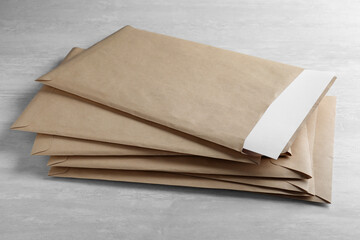 Stack of big kraft paper envelopes on light table, closeup