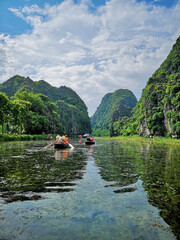 Vertical shot of the tourists traveling in boats in Ninh Binh, Vietnam