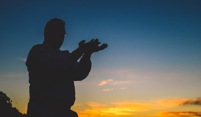 Silhouette of a male practicing martial art on the scenic sunset background