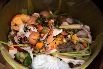 Śmieci mieszane w domowym śmietniku. Odpadki z jedzenia, pieluchy, skorupki jajek, woreczek po herbacie.