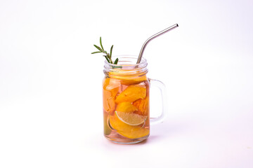 Fototapeta na wymiar Glass of juice with peach slices, rosemary and straws on white background. Refreshing summer drinks.