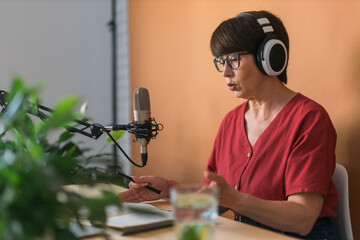 Middle-aged woman radio host making podcast recording for online show - broadcast and dj concept