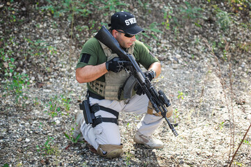 Army soldier shooting with rifle machine gun in the forest