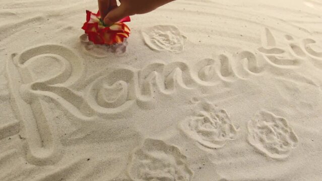 hand draws the inscription Romantic on the sand. Sunny coast of the sea and ocean. Symbol of rest and vacations at the resort