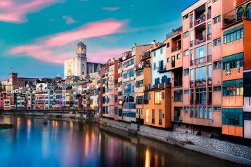 Beautiful view of the medieval city of Girona Spain with canal and historic colorful buildings seen at sunset.