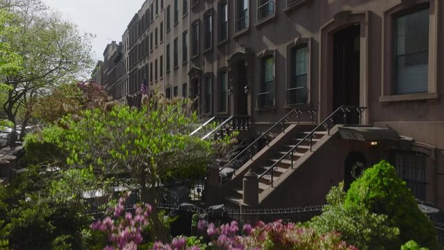 rising shot of classic brownstone block in Brooklyn during spring