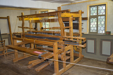 Shot of a wooden shuttle loom machine on a wooden floor in the room